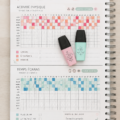 Femme souriante prenant des notes dans un cahier, représentant le suivi de sa vie avec plaisir.